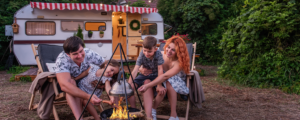 Family enjoying a campfire in front of their RV—perfect moment made possible with an RV loan near you. Explore recreational loan options at Northwoods Credit Union.