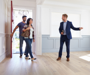 A couple and a realtor viewing a house, representing the home buying process and the importance of mortgage loans, credit union mortgages, and pre-approval