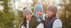 Family outside in winter enjoying snow while practicing mindful holiday budgeting