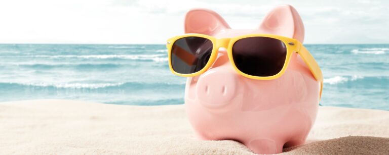 "Piggy bank on a sunny beach illustrating how a Northwoods Credit Union savings account helps money grow."